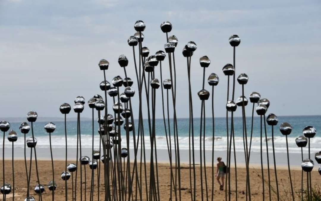 Silver sculpture in front of waves at Lorne Sculpture Biennale